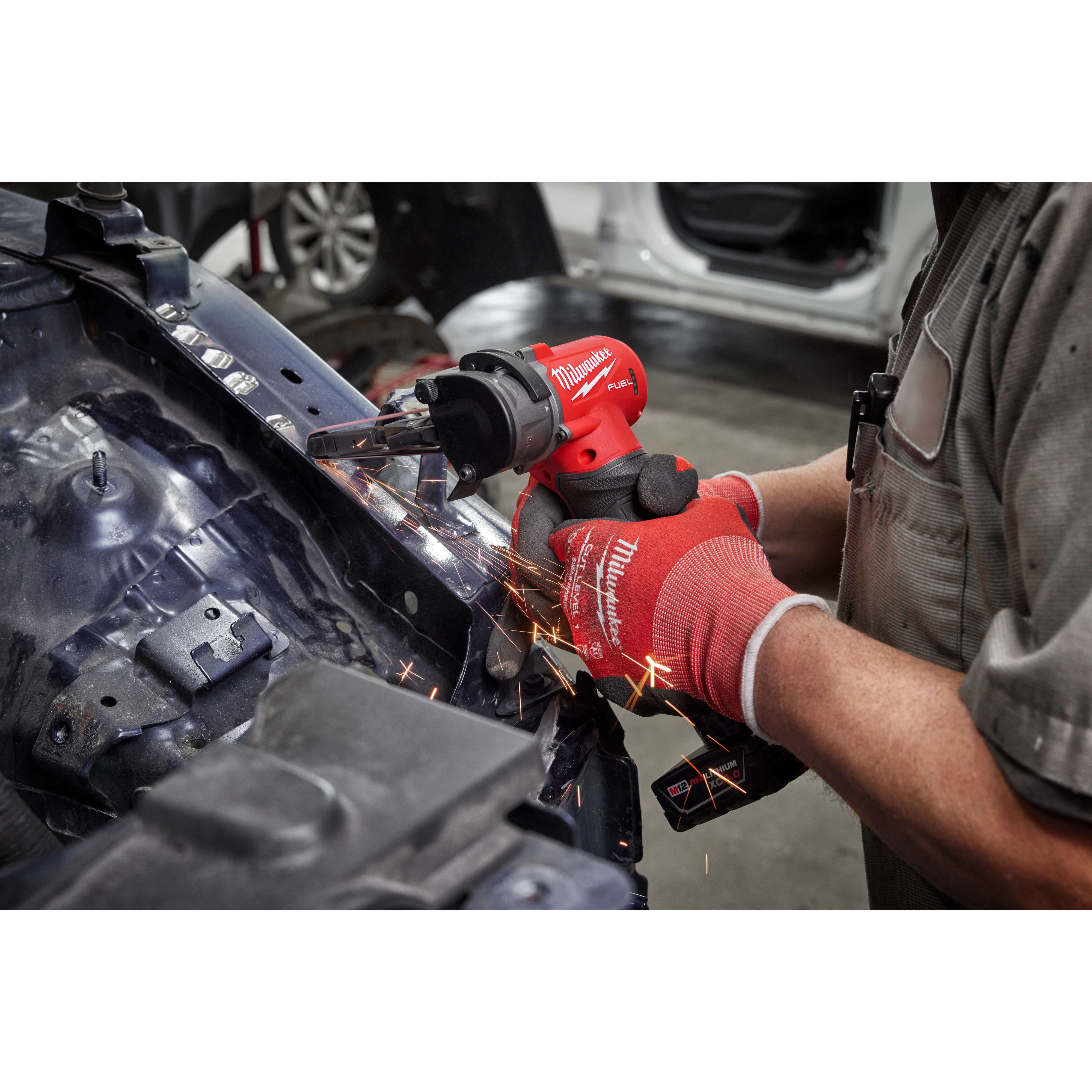 Worker using the M12 FUEl Bandfile for automotive use