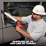 A person operates an M12 12-Volt Lithium-ion Cordless 20 oz. Aluminum Barrel Caulk and Adhesive Gun Kit on a window frame. The image text states that the device supplies up to 400 lbs of thrust.