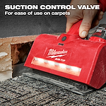A hand using the red M12™ AIR-TIP™ Utility Nozzle on a carpet. The nozzle has a suction control valve for ease of use on carpets. A partially exposed wall is visible in the background. Text on the image highlights the suction control valve feature.